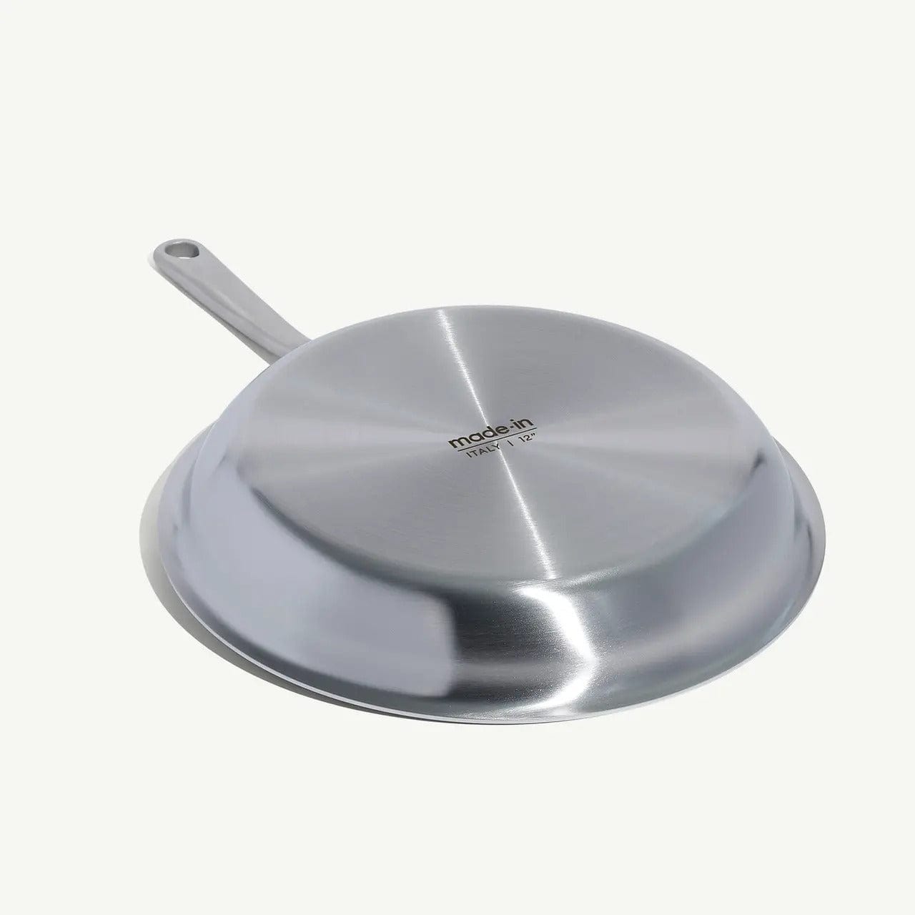 12 stainless clad frying pan shown upside down revealing the shiny brushed metal bottom and handle