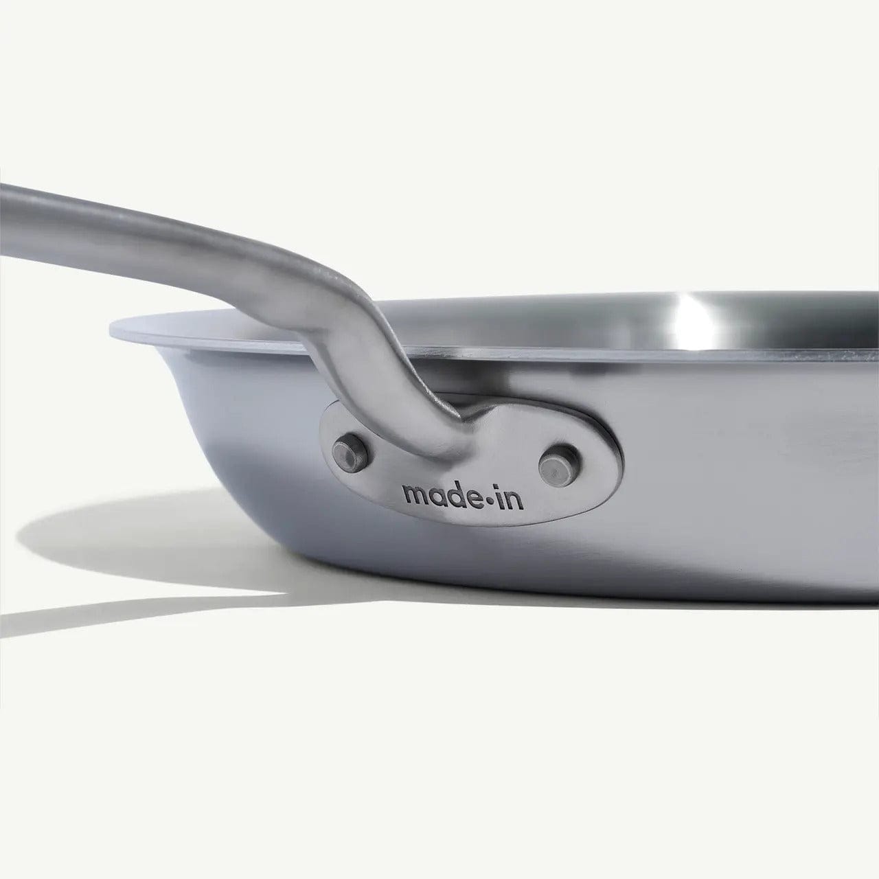 Side view of a 12 Stainless Clad Frying Pan with a metal handle the made-in logo visible on the pan