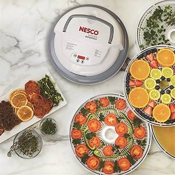 Nesco Snackmaster 4-Tray Digital Dehydrator with white base and gray lid surrounded by dried fruits vegetables and jerky
