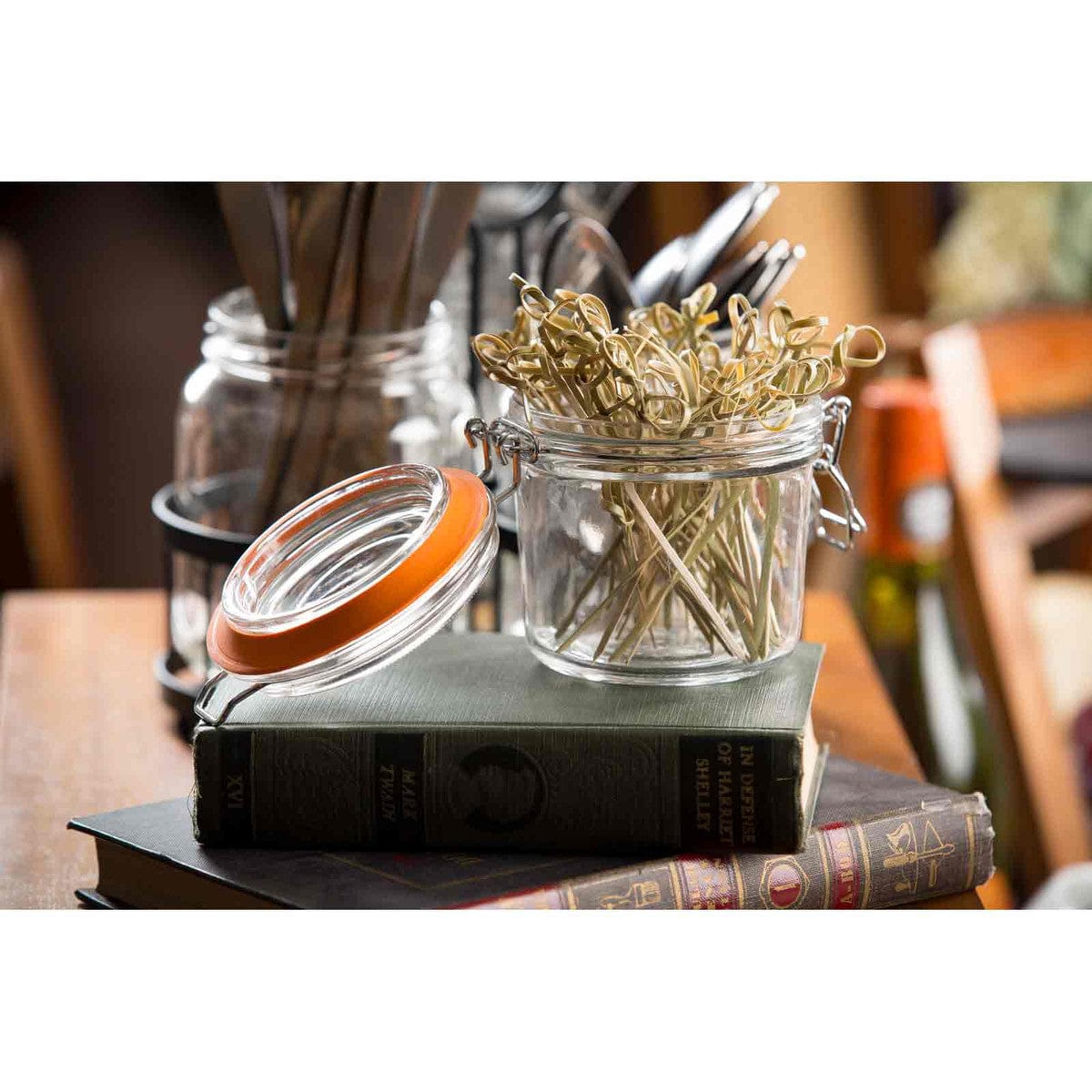A jar filled with many 4 5 light brown knotted bamboo picks with looped ends