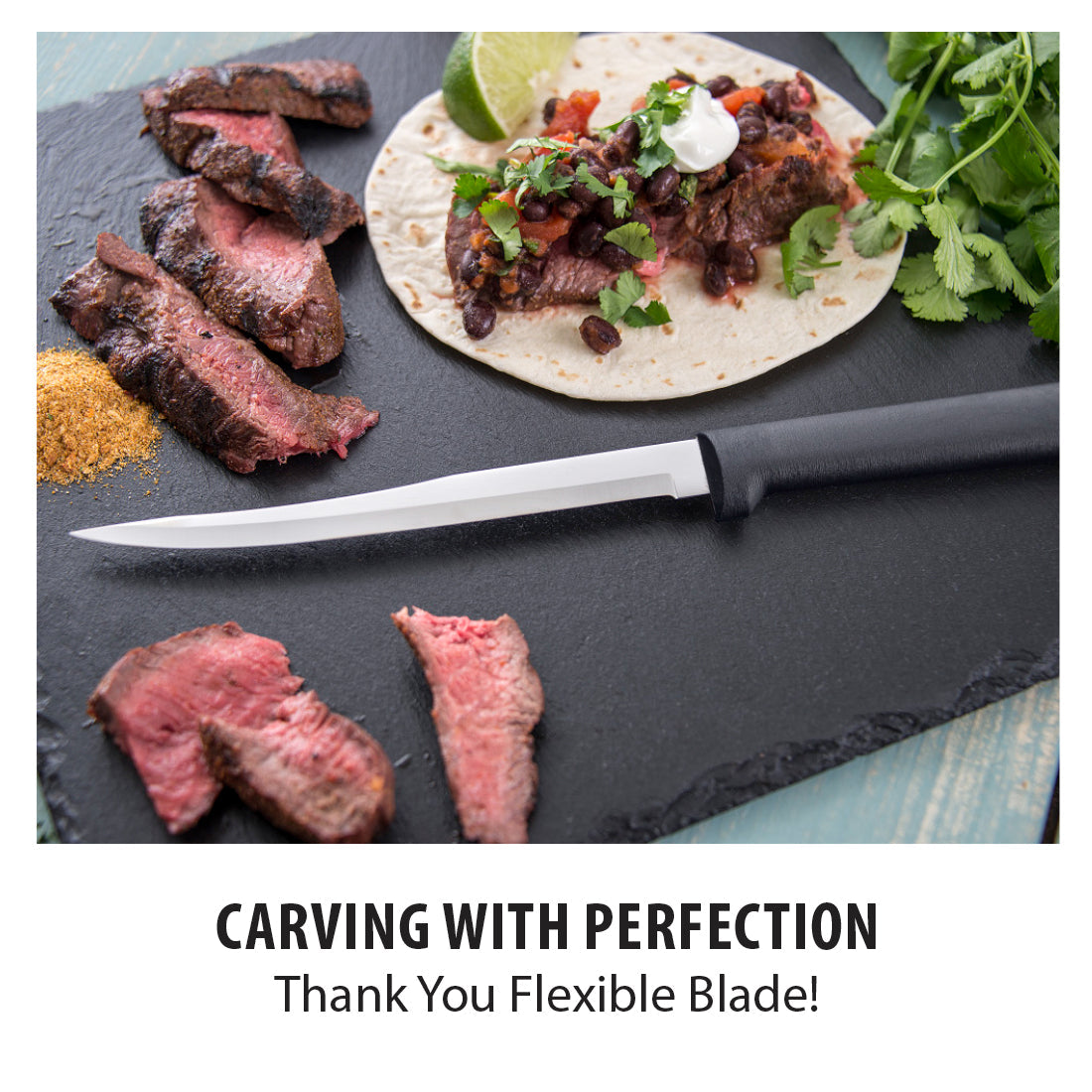 Sabatier black handled boning knife with a flexible stainless steel blade shown next to sliced steak on a black slate