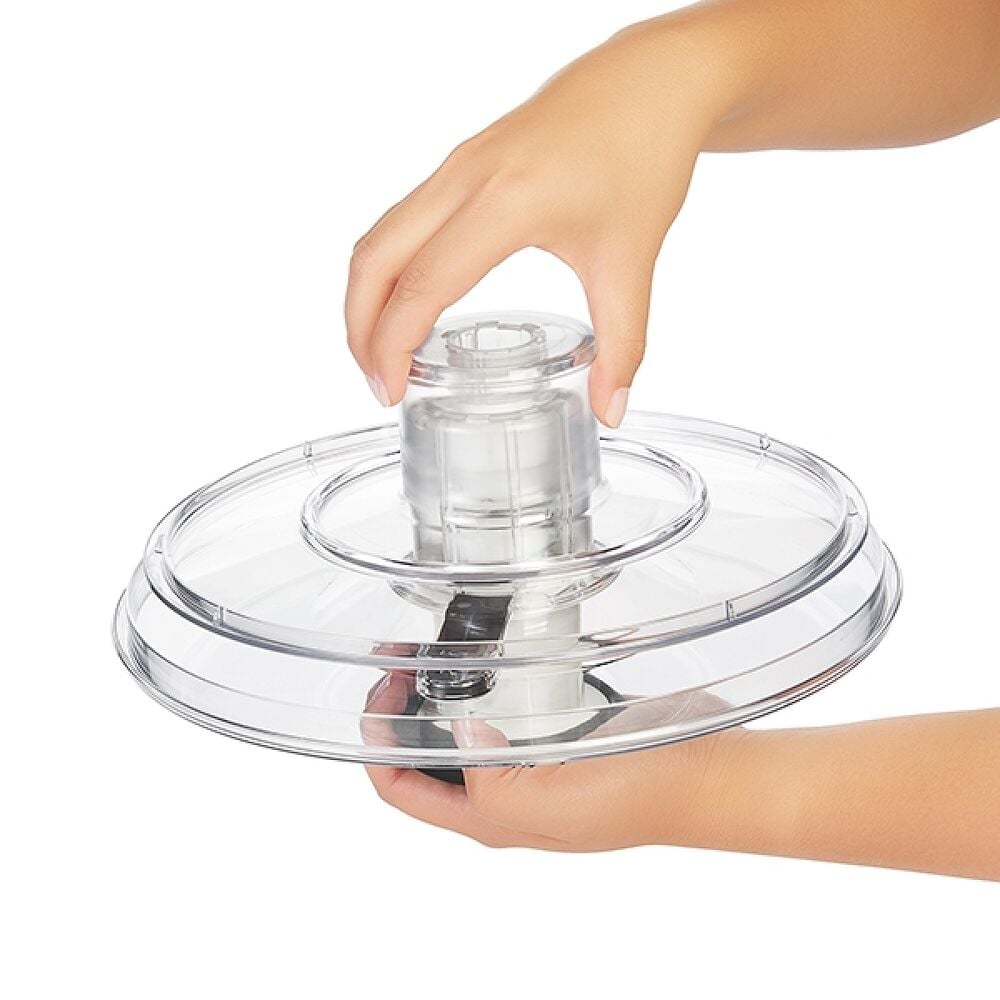KitchenAid 9-cup food processor clear plastic lid with a hand holding the transparent feed tube assembly