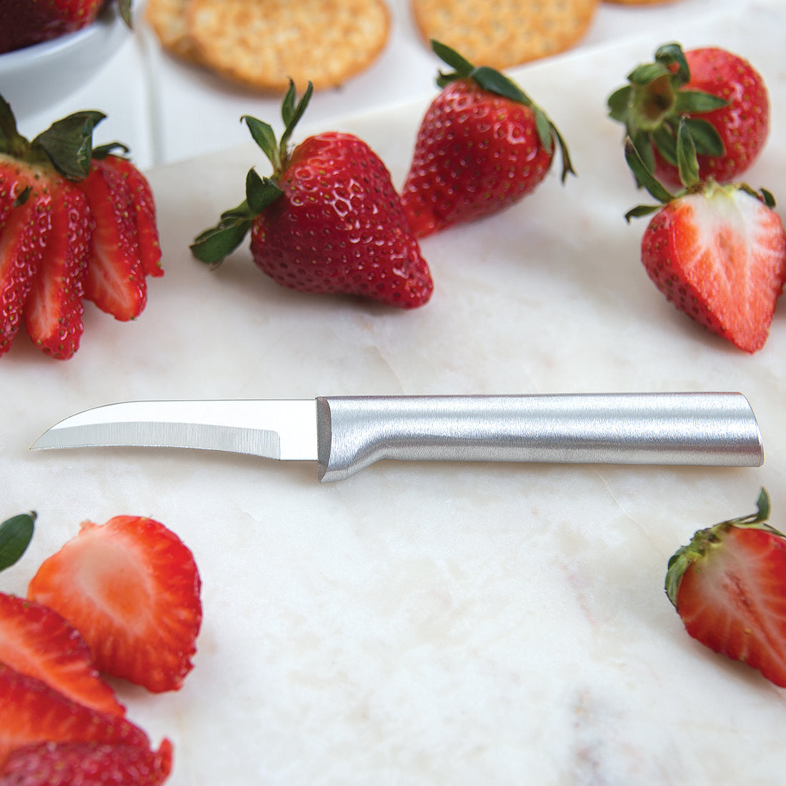 Steel paring knife with silver handle and curved blade ideal for slicing strawberries and other fruit