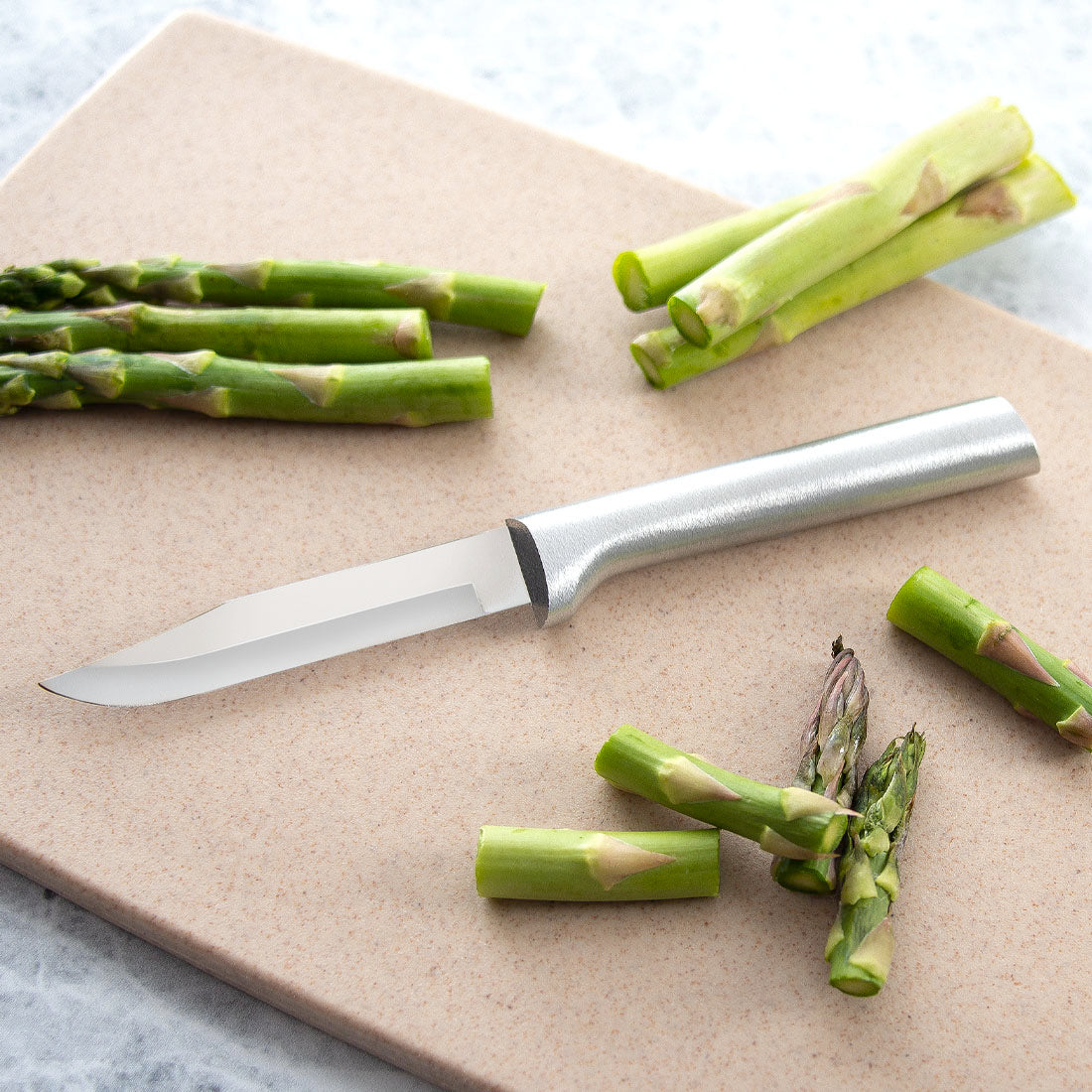 Kramer Stainless Steel Paring Knife sharp silver blade with a sleek silver handle on a light brown cutting board