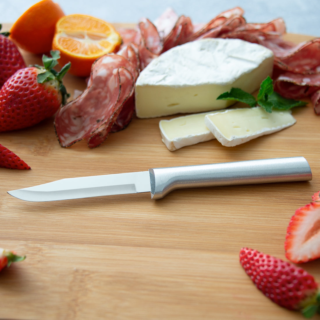Small silver stainless steel cheese knife with a matte finish handle designed for serving and cutting