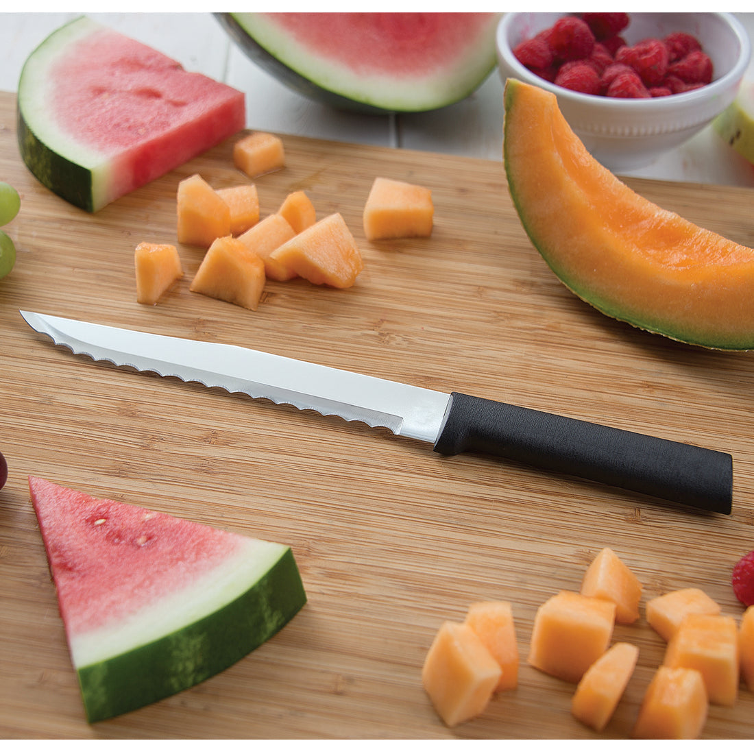Cuisinart Black White Ceramic Wavy Edge Blade Knife for fruit and vegetable prep on a bamboo cutting board