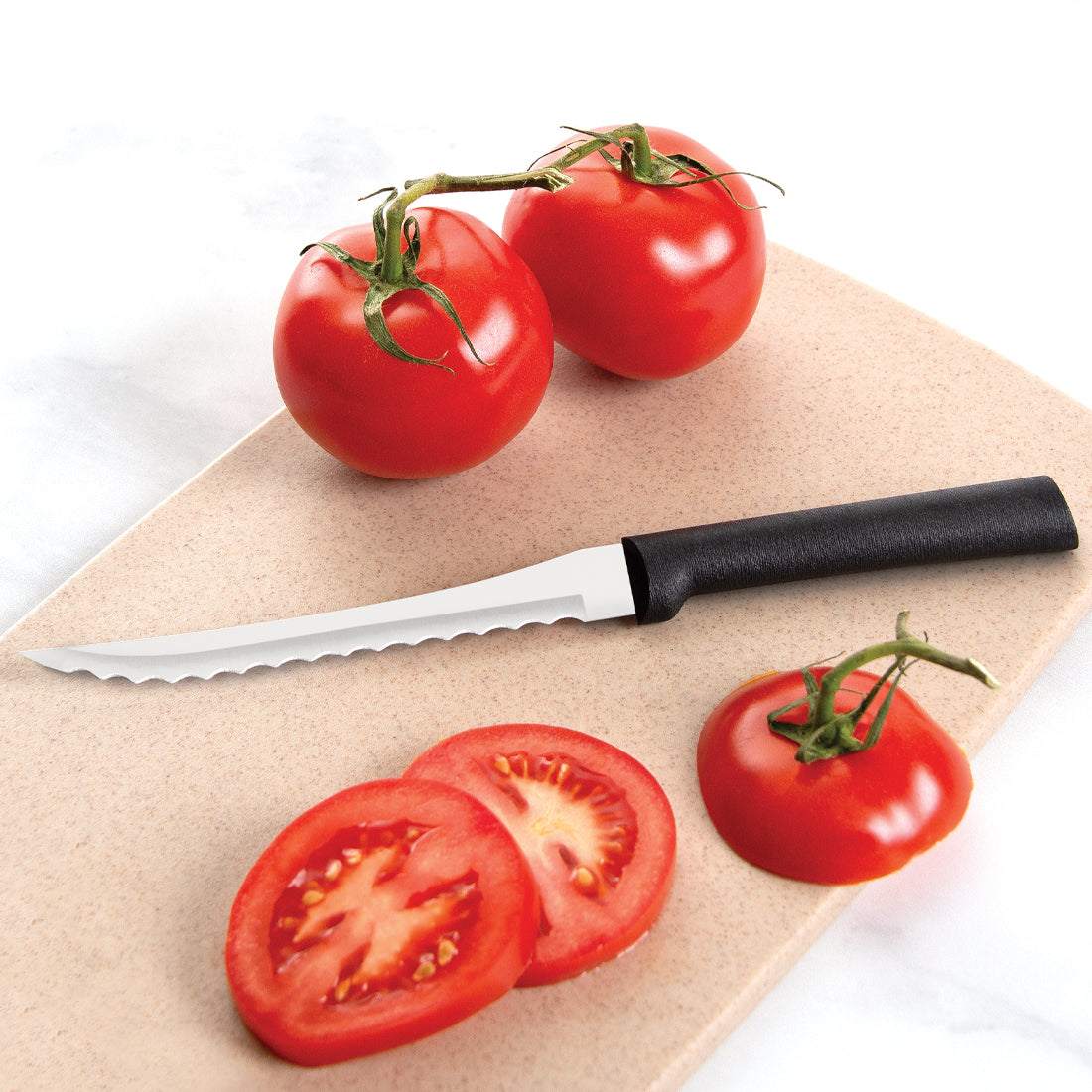 Dexter-Russell Sani-Safe stainless steel serrated utility knife with black handle shown slicing tomatoes